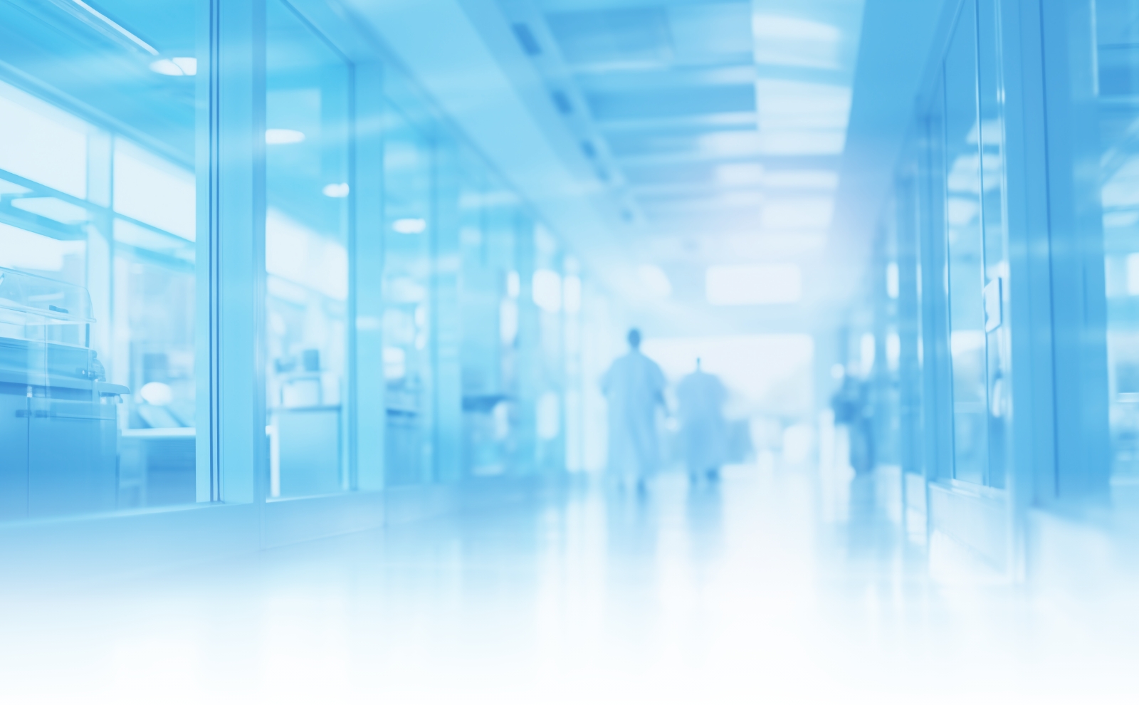 Blurry image of a hallway with several people walking through, creating a sense of movement and activity.